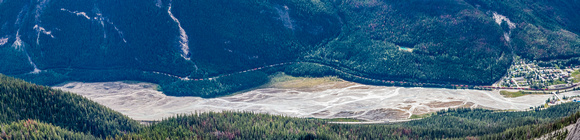 A train winds its way along the Kicking Horse River towards Field.
