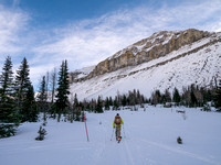Wietse skis past the halfway hut with Redoubt looming over him.
