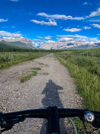 Biking through Ya Ha Tinda towards a distant Warden Rock and the Banff Park boundary.