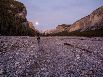 Biking up a surreal landscape along the Ghost River with a very bright moon providing any light we might still need
