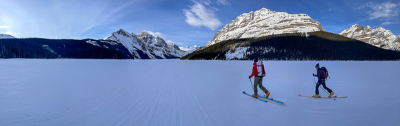 Skiing across Peyto Lake under the east face of Caldron.