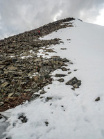 Looking up at Mike descending bouldery terrain on Two O'Clock Peak's SE ridge.