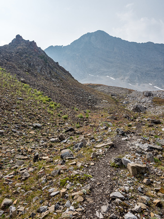 There is a beaten path in the scree that makes the route obvious but does require hiking footwear or you might be slipping around quite a bit.