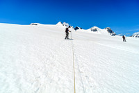Avoiding a crevasse on the  lower south ridge of Christian Peak which rises in the far distance over Ben's head at center.