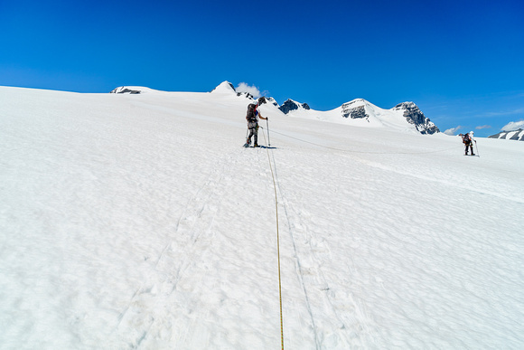 Avoiding a crevasse on the  lower south ridge of Christian Peak which rises in the far distance over Ben's head at center.