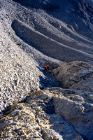 Traversing rubble slopes to the upper scree and slab ramp.