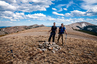 Vern and Keith try to stay vertical in the strong wind(!) on the summit of Windy Peak. Saddle on the left and Hornecker and Livingstone on the right
