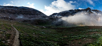 North Molar Pass wreathed in mist rises above the alpine meadows.