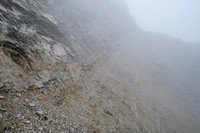 Eventually forced east onto a rising scree bench under the south ridge.